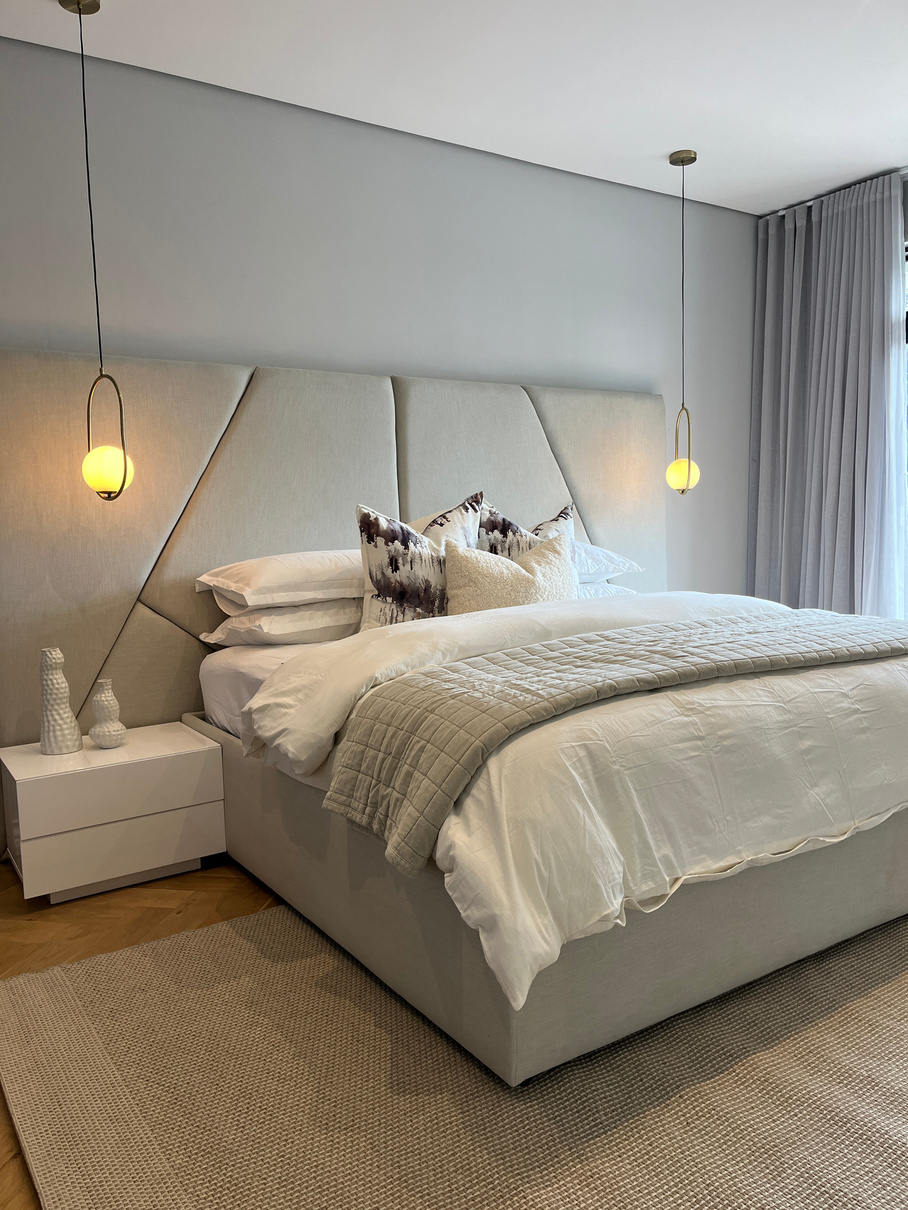 Bedroom with upholstered headboard and pendant lighting